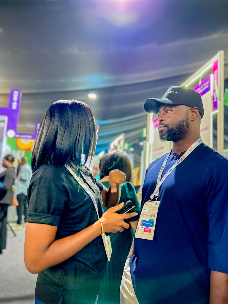 A TruthVein exhibitor talking with a visitor on the GITEX floor